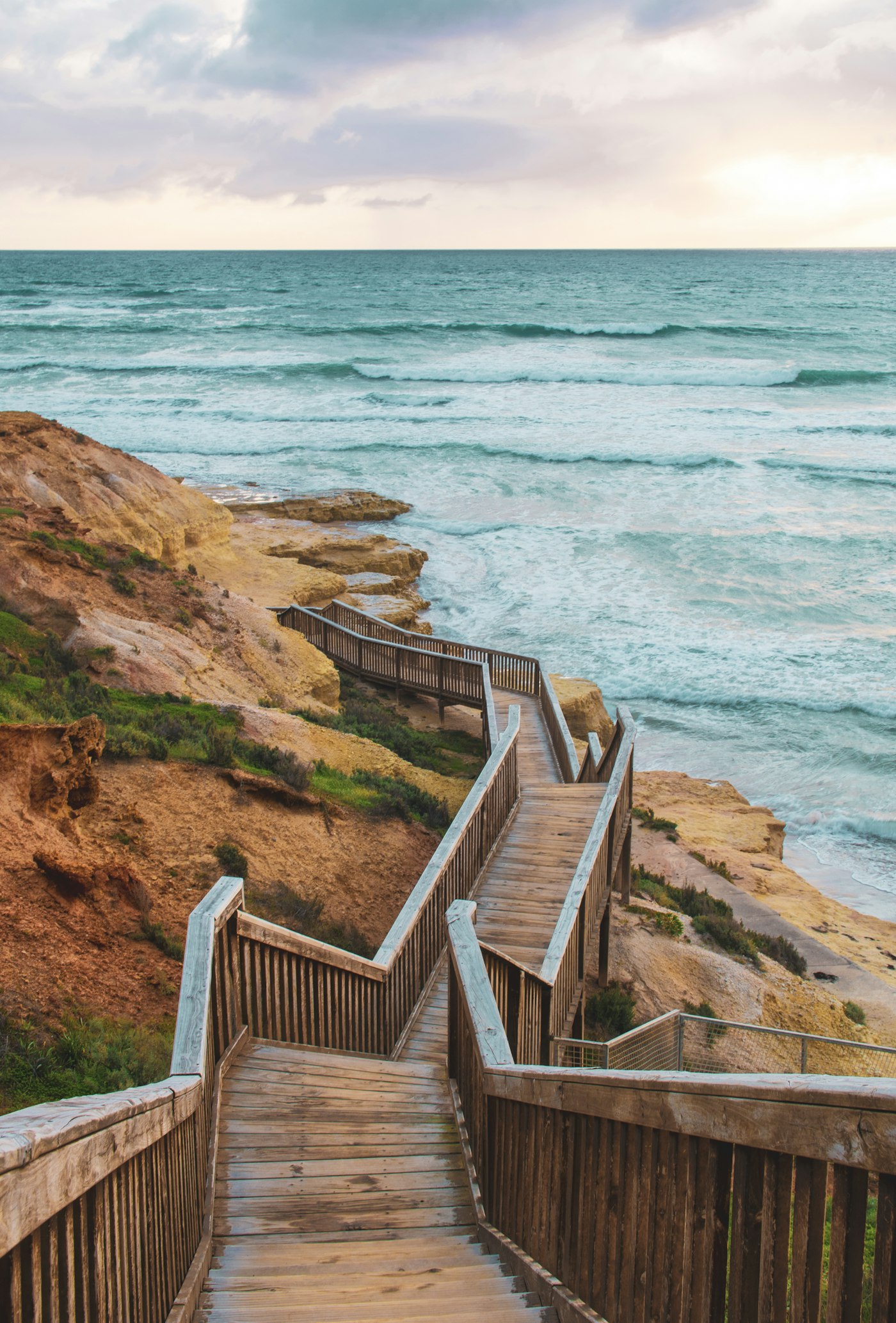 Timber boardwalk winding down the cliffs to an Adelaide beach